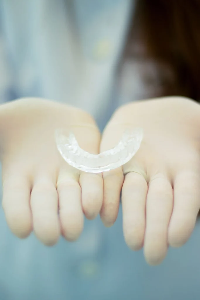 Custom clear bruxism night guard held in hands