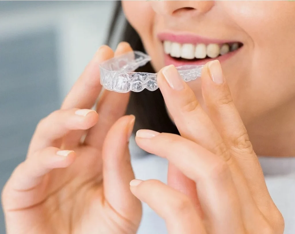 Woman inserting a clear aligner for teeth straightening